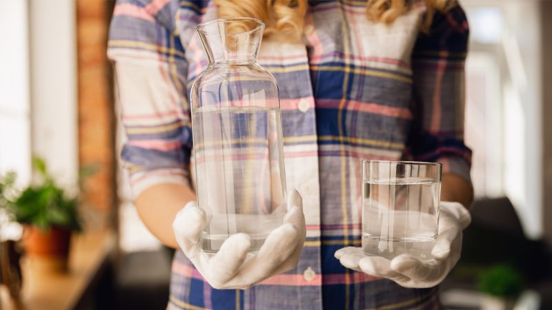 holding bottle and glass with moldy water