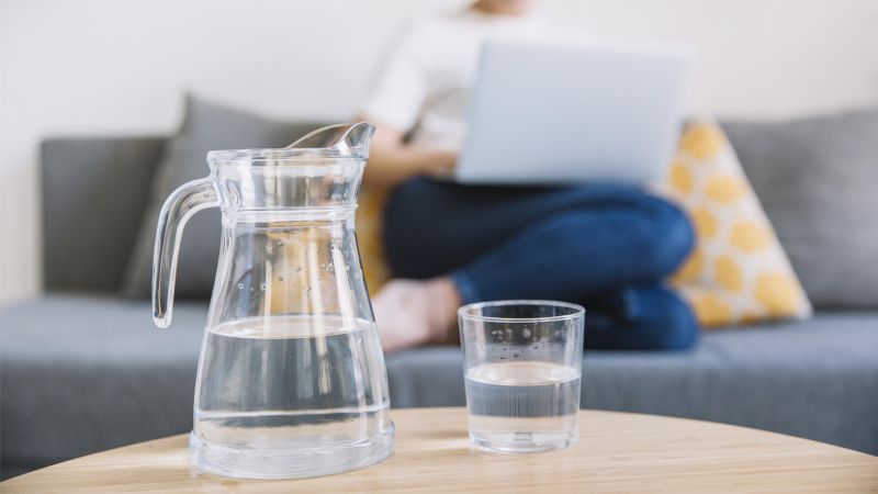 jug and glass of water near pregnant woman