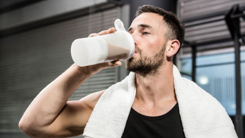 muscular man drinking protein shake